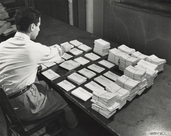 Man sorting cards on large table.