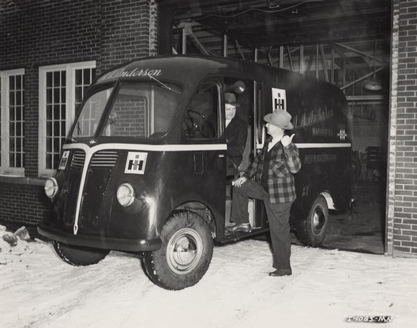 Two men talking, one behind the wheel of an International truck and the other standing outside. The International KB-3 truck with Metro body was owned by A.A. Anderson, an International Harvester dealership specializing in refrigeration.