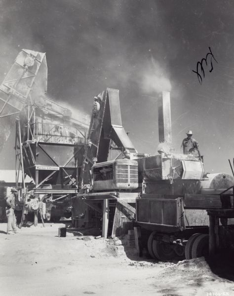 Two men working at Collins Construction Company using International Diesel power units at the Barber Greene hot-mix plant.