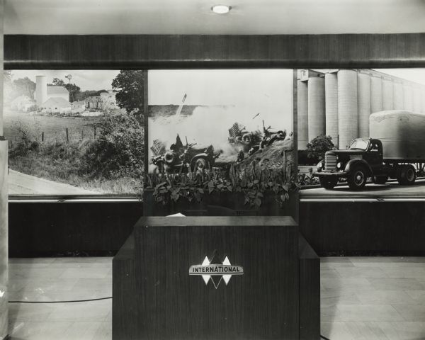 Three enlarged photograph murals inside the Harvester building, 6th floor. The image on the left is a farm, the middle image is a war scene, and the one on the right is of a truck in front of industrial buildings.
