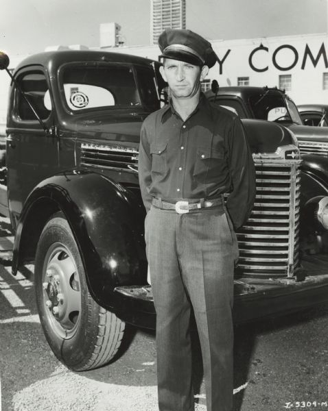 International truck driver, identified as "driver of the month," standing in front of his truck.