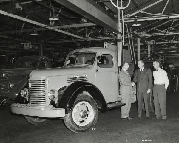 Heavy duty International truck coming off the assembly line at International Harvester's Fort Wayne Works. Men in the picture are, from left to right: "C. M. Harrison, superintendent of Fort Wayne Works, I.W. Davis, Assistant Works manager (motor trucks), and P.T. Brantingham, assistant chief engineer Fort Wayne Works."