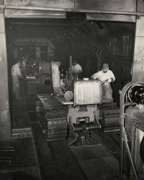 Factory workers painting crawler tractors (TracTracTors) at International Harvester's Tractor Works.