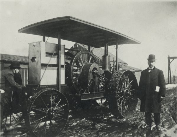 Two men with a 10 HP friction drive tractor.
