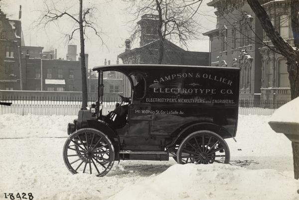 An International model M truck operated by Sampson & Ollier Electrotype Company. The truck is parked on a snow-covered street.