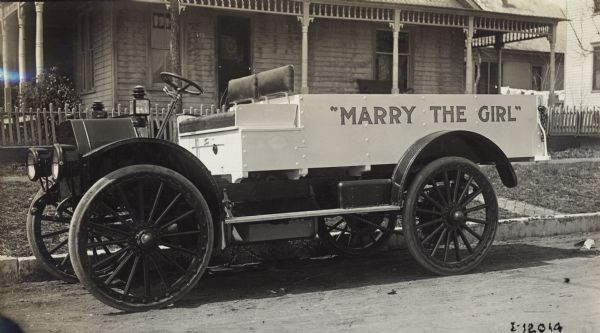 International truck parked on a street outside a suburban residence. The words "Marry the Girl" are painted on the side.