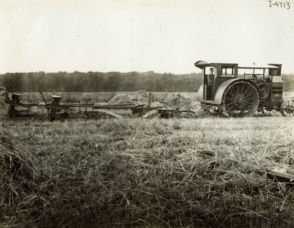 Man pulling a plow, harrow and planters with a Mogul 25 h.p. tractor.