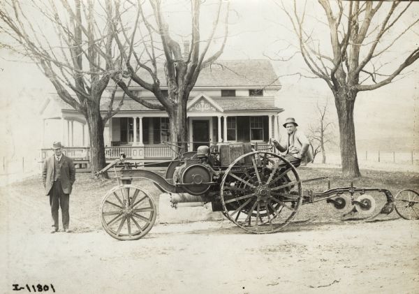 Father and son outside a house with a Mogul 8-16 tractor.