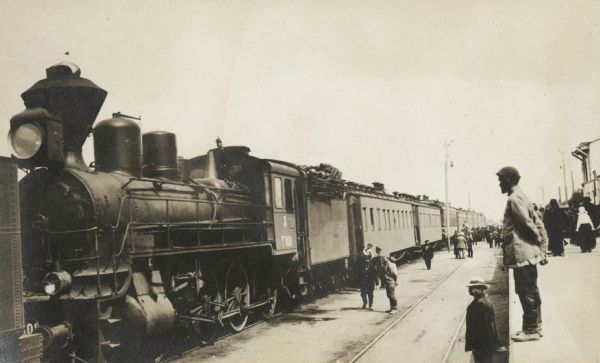 Group of people at a railroad platform near the "Imperial train" used by the Root Commission as they traveled through Russia.