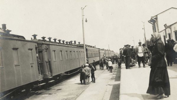 Group of people at a railroad station in Manchuria, gathered near the "Imperial train" that carried the Root Commission members through Russia.
