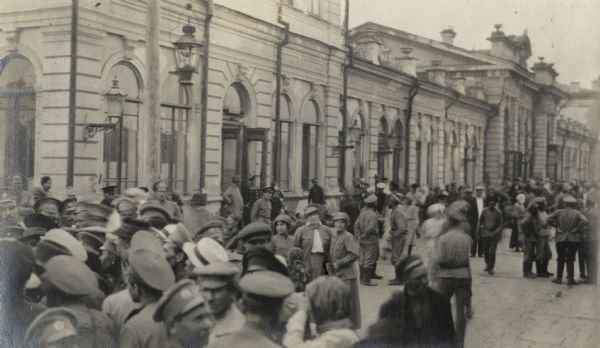 Soldiers and civilians on a street near the train station at Irkutsk, Russia. Original caption reads: "station scene at Irkutsk."