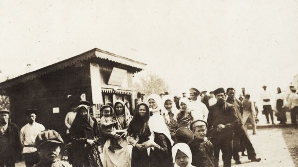 Group of men, women and children at Mogzon, Russia, along the Trans-Siberian Railway. Original caption reads: "group of peasant women at Mogzon."