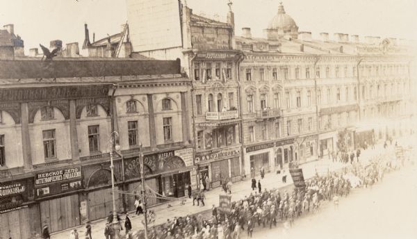 Parade down a city street in Petrograd (St. Petersburg), Russia. There are numerous shops and storefronts. Original caption reads: "parade on Nevski Prospekt."