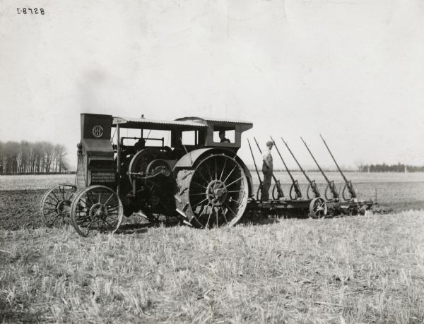 Men plow a field with a Mogul 15-30 tractor.