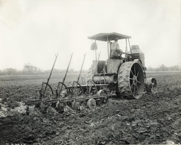 Tractor pulling a P&O plow in a field.