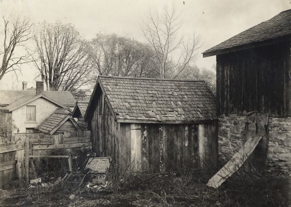 View of a barn, shed, and fence, used to illustrate places where mites and lice might breed.