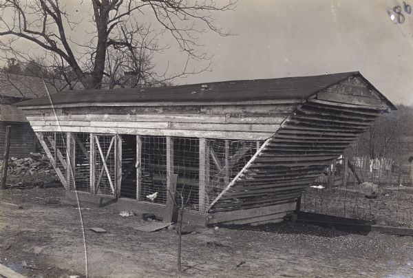 Exterior view of a chicken coop, or poultry house made of wood and wire.