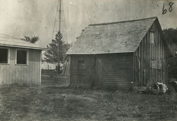 View of a barn and chicken coop, used to illustrate the poor quality of the coop.