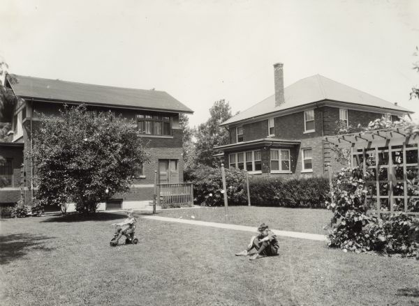 Two young boys playing in the backyard of a suburban residence.