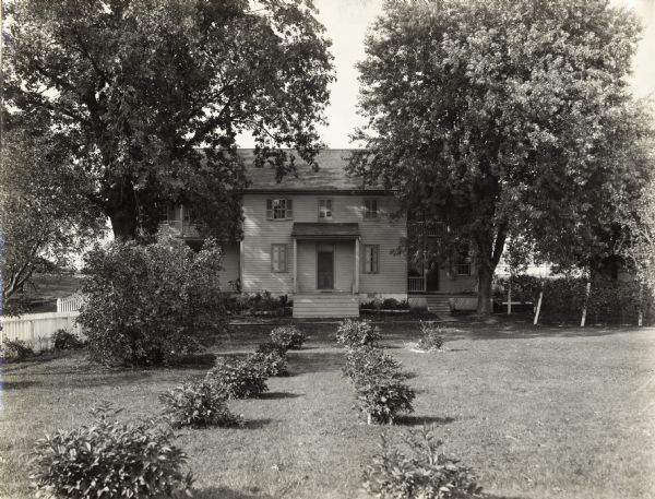 Farmhouse with landscaping of shrubbery. Original caption reads: "Nice possibilities, poor arrangement, no planting plan."