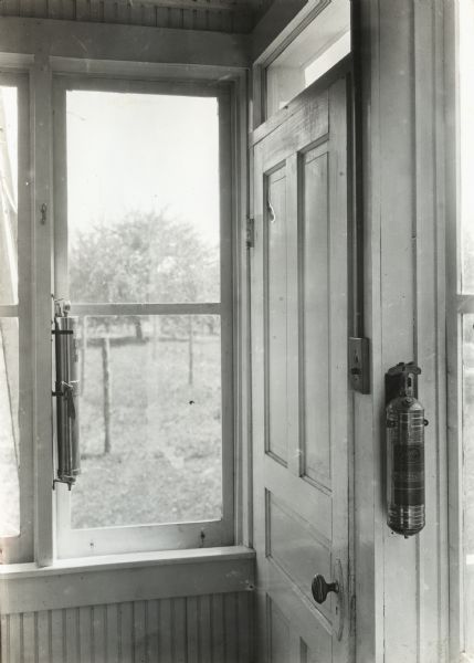 View of two wall-mounted fire extinguishers inside a building on the farm of Professor Holden.