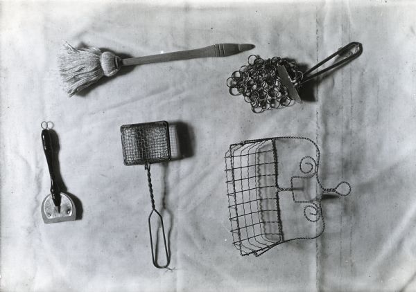 View of five kitchen(?) tools laid on a light-colored background.
