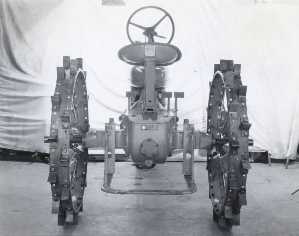 Studio shot of a Farmall H tractor with steel wheels and H Spade, showing seat decal and IHC's "Safety First" below the seat. The tractor may be an experimental model.