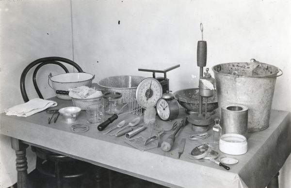 View of a table set with various utensils and supplies used in food canning.
