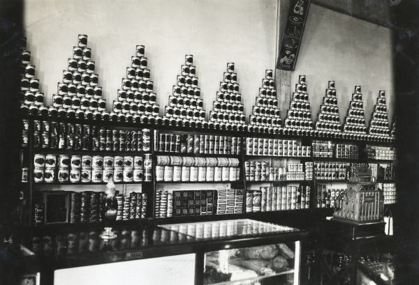 Canned goods are arranged on shelving against a wall inside a grocery store.
