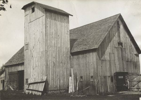 Exterior view of square wooden silo next to a barn at "Mr Fox's Farm". 
