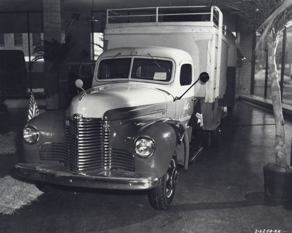 Original caption reads: "International motor trucks used by Gatti-Hallicrafters Expeditions shown inside and outside of Manhattan showrooms, International Harvester Company, motor trucks division."