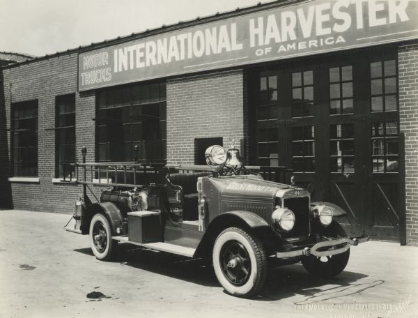 International fire truck parked outside an International Harvester dealership. The truck was used by the Brentwood Fire Department.