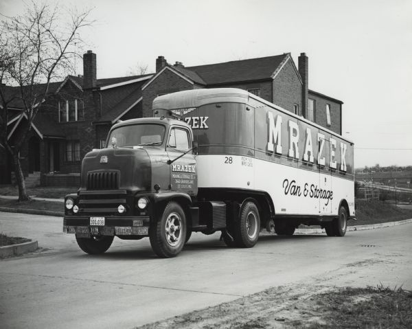 International truck used by Mrazek moving and storage company parked on street outside residence.