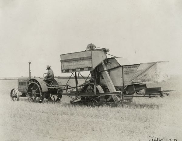 McCormick-Deering Power Drive harvester-thresher (combine) pulled by a 15-30 tractor. Decals and/or stencils are on the machines that read: "McCormick-Deering &#8212; No. 8 &#8212; Power Drive. Harvester-Thresher Patents Pending".