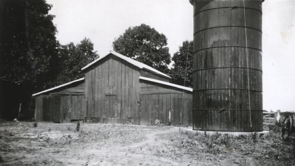 Exterior view of a barn and silo at an International Harvester demonstration farm.
