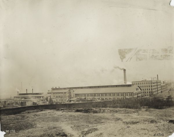 Exterior view from field of factory buildings at International Harvester's Milwaukee Works.