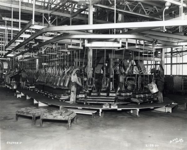 Men are using Champion Jolt Squeeze molding machines in the molding unit at International Harvester's Osborne Works factory.