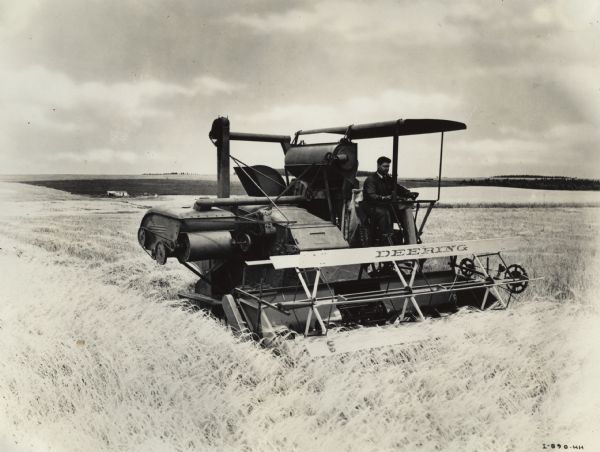 Man driving an experimental Deering #123 self propelled harvester-thresher (combine). Original caption reads: "Argentina, South America-Deering #123 self propelled harvester thresher 12 feet cut harvesting wheat. Equipped with re-cleaner (extreme left) and grain classifier (back of operator.)"