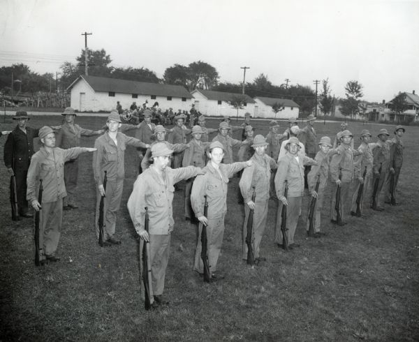 Group of Army recruits in formation. Original caption reads: "The 609th Ordnance Base Armament Maintenance Battalion, recruited from IH operations... pictured during basic training at Camp Perry."