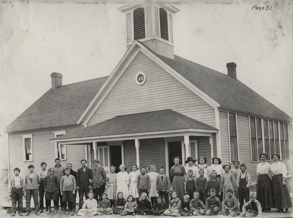Group portrait of students and teachers of the Woldale High School outside their school building.