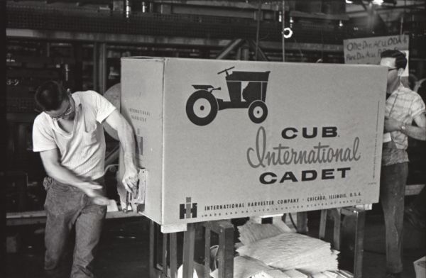 Factory workers at Louisville Works pack a Cub Cadet inside a cardboard box in preparation for shipment by rail to International Harvester dealerships.