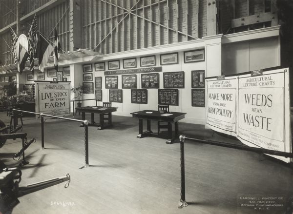 International Harvester Agricultural Extension exhibit, including lecture charts with the titles: "Live Stock on Every Farm," "Make More From Your Poultry," and "Weeds Mean Waste."