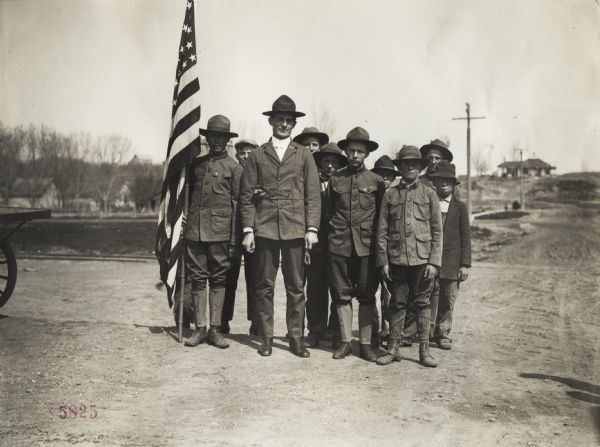 Group of Boy Scouts standing outdoors in uniform with a troop leader and an American flag. Original caption reads: "Union Pacific Nebraska Preparedness Special Campaign."