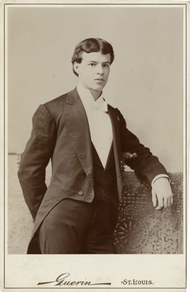 Carte-de-visite of a three-quarter length portrait of Hugh Claiborne Adams, age 18, dressed in coattails with his arm on the back of an elaborately carved chair.