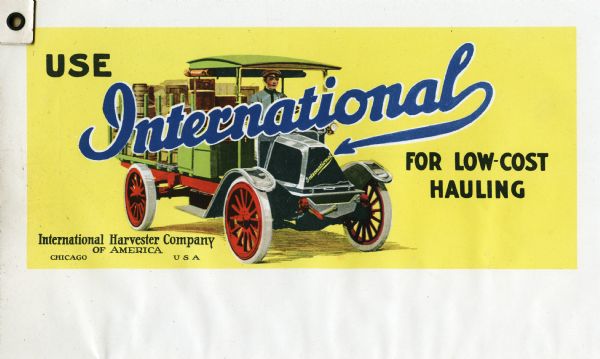 Billboard design for International motor trucks featuring an illustration of a man driving a green automobile loaded with wooden crates. The text on the billboard reads: "Use International for Low-Cost Hauling. International Harvester Company of America. Chicago USA."