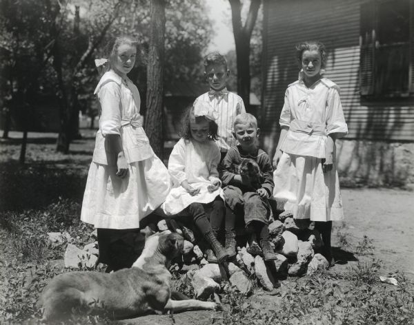 A group of male and female students from Sunnyside School posing for an outdoor portrait with a dog and cat.