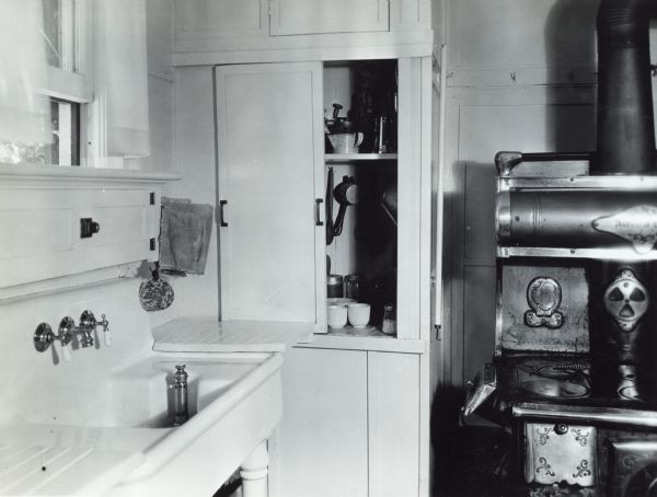 View of a sink, cupboard, and stove in the farmhouse kitchen of Miss Marilla Zearing.