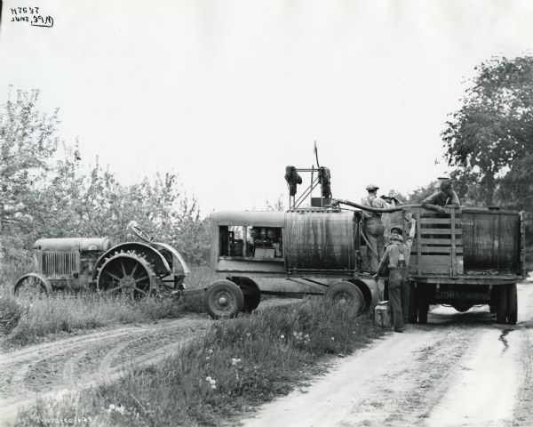 Four men use a 150 gallon sprayer and a McCormick-Deering 10-20 tractor to apply pesticide to an orchard. The photograph was taken in Markham, Ontario, Canada.
