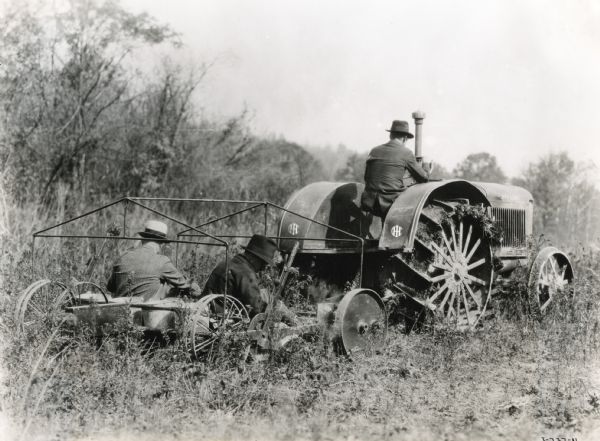 Men use a McCormick-Deering 15-30 tractor and a "reforestation machine" as they plant trees for timber production.