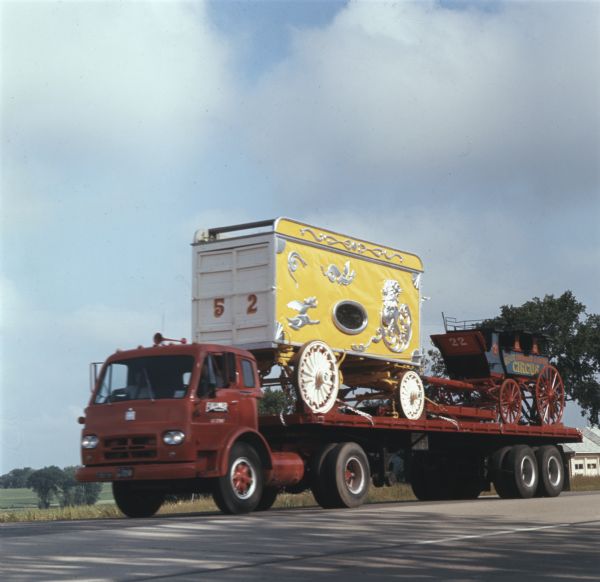 An International truck transports a circus wagon between Circus World Museum in Baraboo and Milwaukee. The wagon was part of a 25-piece circus parade sponsored by Jos. Schlitz Brewing Company.